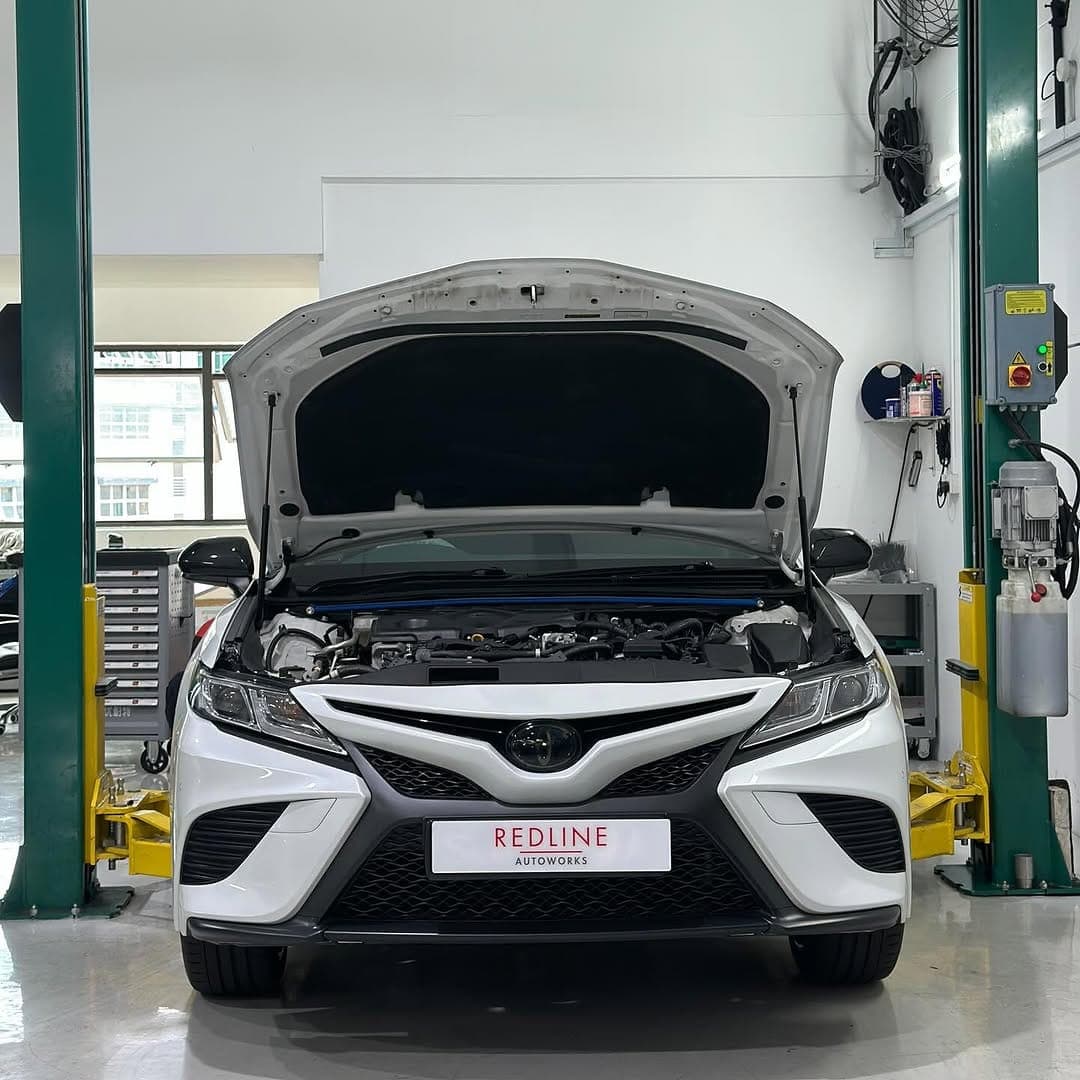 Toyota Camry with bonnet open for servicing